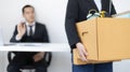 Young woman wearing a black suit raises a brown cardboard box from the office Royalty Free Stock Photo