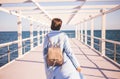 Young woman wearing blue coat walking near the sea. Royalty Free Stock Photo