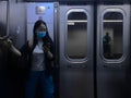 Young Woman Wearing Blue Face Mask Riding Subway Train in New York City During Coronavirus Pandemic NYC