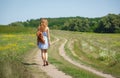 Young woman with a leather backpack on a summer rural road Royalty Free Stock Photo