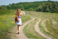 Young woman with a leather backpack on a summer rural road Royalty Free Stock Photo