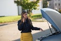 Young woman and broken car