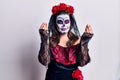 Young woman wearing day of the dead costume over white doing money gesture with hands, asking for salary payment, millionaire