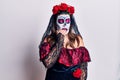 Young woman wearing day of the dead costume over white looking stressed and nervous with hands on mouth biting nails