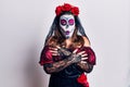 Young woman wearing day of the dead costume over white shaking and freezing for winter cold with sad and shock expression on face Royalty Free Stock Photo