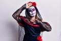 Young woman wearing day of the dead costume over white smiling cheerful playing peek a boo with hands showing face