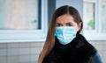 Young woman wearing disposable blue face mouth nose mask. covid-19 outbreak prevention illustration