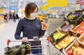 Young woman wearing disposable medical mask shopping in supermarket during coronavirus pneumonia outbreak Royalty Free Stock Photo