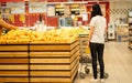 Young woman wearing disposable medical mask shopping in supermarket during coronavirus pneumonia outbreak. Royalty Free Stock Photo