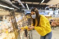 Young woman wearing disposable medical mask shopping in supermarket during coronavirus pneumonia outbreak. Protection and prevent Royalty Free Stock Photo