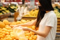 Young woman wearing disposable medical mask shopping in supermarket during coronavirus pneumonia outbreak. Royalty Free Stock Photo