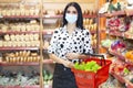 Young woman wearing disposable medical mask shopping in supermarket during coronavirus pneumonia outbreak. Royalty Free Stock Photo