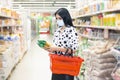 Young woman wearing disposable medical mask shopping in supermarket Royalty Free Stock Photo