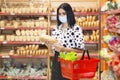 Young woman wearing disposable medical mask shopping in supermarket Royalty Free Stock Photo