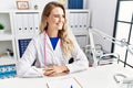 Young woman wearing doctor uniform smiling confident at clinic Royalty Free Stock Photo