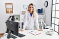 Young woman wearing doctor uniform smiling confident standing at clinic Royalty Free Stock Photo