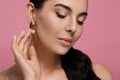 Young woman wearing elegant pearl earrings on pink background, closeup Royalty Free Stock Photo
