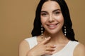 Young woman wearing elegant pearl jewelry on brown background, space for text Royalty Free Stock Photo