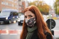 Young woman wearing everyday cloth face mask outdoors in city raffic