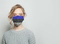 Young woman wearing a face mask with estonian national flag. Flu epidemic and virus protection concept