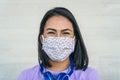 Young woman wearing face mask portrait - Latin girl using protective facemask for preventing spread of corona virus