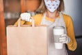 Young woman wearing face watermelon mask while serving takeaway food and coffee inside bar cafeteria - Worker preparing healthy Royalty Free Stock Photo