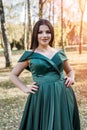 Young woman wearing fashionable green dress walking in autumn park Royalty Free Stock Photo