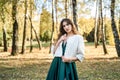 Young woman wearing fashionable green dress walking in autumn park Royalty Free Stock Photo