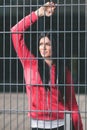 Young woman looking from behind the bars Royalty Free Stock Photo