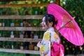 A young woman wearing a Japanese traditional kimono or yukata holding an umbrella is happy and cheerful in the park Royalty Free Stock Photo