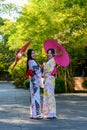 A young woman wearing a Japanese traditional kimono or yukata holding an umbrella is happy and cheerful in the park Royalty Free Stock Photo