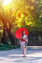 A young woman wearing a Japanese traditional kimono or yukata holding an umbrella is happy and cheerful in the park Royalty Free Stock Photo