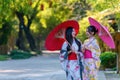 A young woman wearing a Japanese traditional kimono or yukata holding an umbrella is happy and cheerful in the park Royalty Free Stock Photo