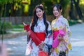 A young woman wearing a Japanese traditional kimono or yukata holding an umbrella is happy and cheerful in the park Royalty Free Stock Photo