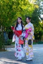 A young woman wearing a Japanese traditional kimono or yukata holding an umbrella is happy and cheerful in the park Royalty Free Stock Photo