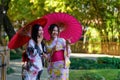 A young woman wearing a Japanese traditional kimono or yukata holding an umbrella is happy and cheerful in the park Royalty Free Stock Photo