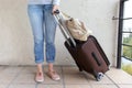 Young woman wearing jeans carry a luggage bag. Travel and relocation concept.