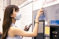 Young woman wearing mask and buying tickets for public transportation Royalty Free Stock Photo