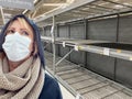 Young Woman Wearing Medical Face Mask In Empty Aisle of Grocery Store