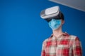 Young woman wearing medical face mask and virtual reality headset - VR concept