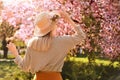 Young woman wearing outfit in park on spring day, back view. Fashionable look