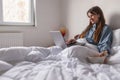 Woman having breakfast and using laptop computer in bed Royalty Free Stock Photo