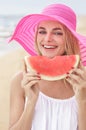 Young woman wearing pink sunhat smiling and eating watermelon Royalty Free Stock Photo