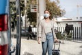 A young woman wearing protective mask boarding the bus with a luggage Royalty Free Stock Photo