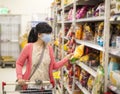 Young woman wearing protective mask and buying food in supermarket Royalty Free Stock Photo