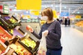 Young woman wearing protective medical face mask shopping in supermarket during coronavirus pneumonia outbreak Royalty Free Stock Photo