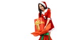 Young woman wearing red santa claus outfit picking up gift box or present from Santa Claus Bag for giving gift isolated on white b Royalty Free Stock Photo