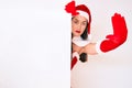 Young woman wearing santa claus costume holding blank empty banner with open hand doing stop sign with serious and confident Royalty Free Stock Photo