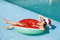 Young woman wearing Santa Claus hat on inflatable ring in swimming pool. Christmas vacation Royalty Free Stock Photo