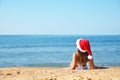 Woman wearing Santa hat and bikini on beach, space for text. Christmas vacation Royalty Free Stock Photo